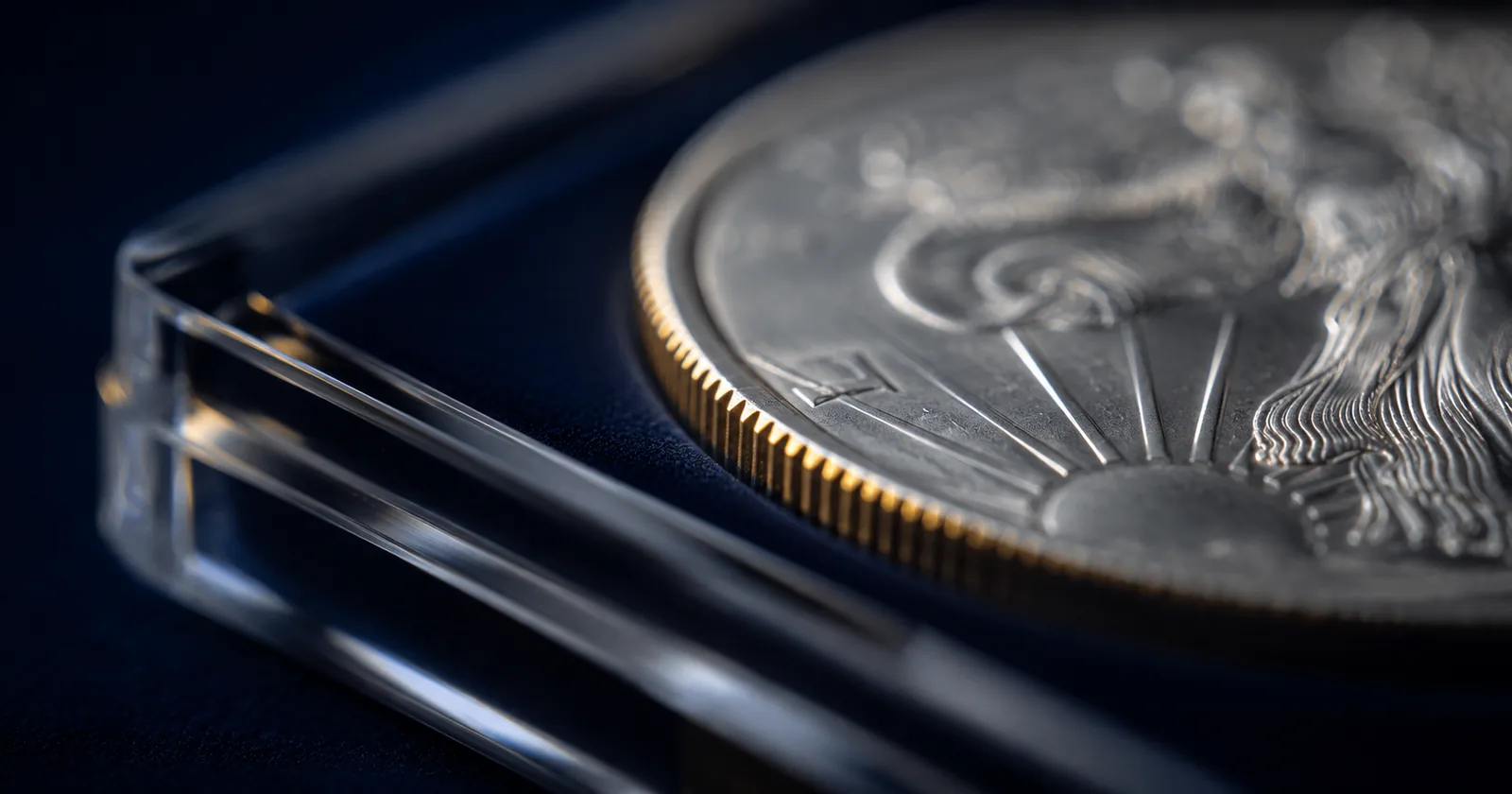 Coin holder edge lit dramatically showing encapsulated coin rim